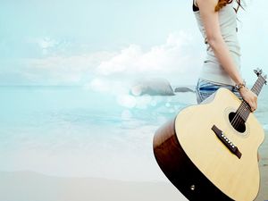 女孩抱著吉他海濱PPT背景圖片