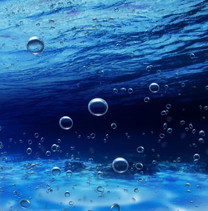 Podwodne rosnące pęcherzyki na niebieskim tle obraz